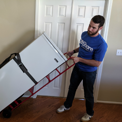 Delivery Professional using appliance dolly to move a freezer