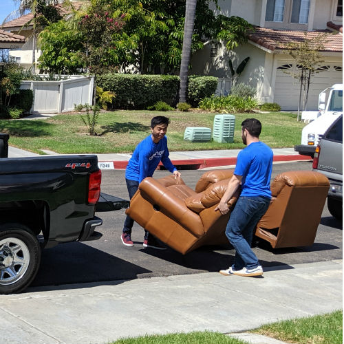 How to Move a Couch - Two Men Lifting a piece of a sectional onto a pickup